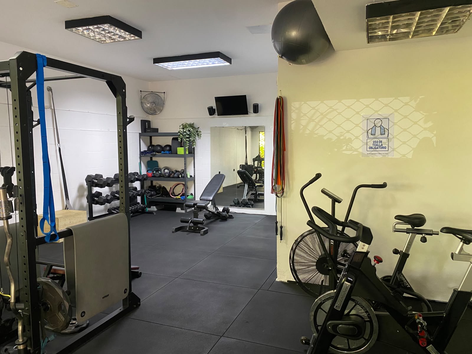 Sala de Salud y Fuerza con rack, bicicletas de aire y equipamiento para grupos reducidos